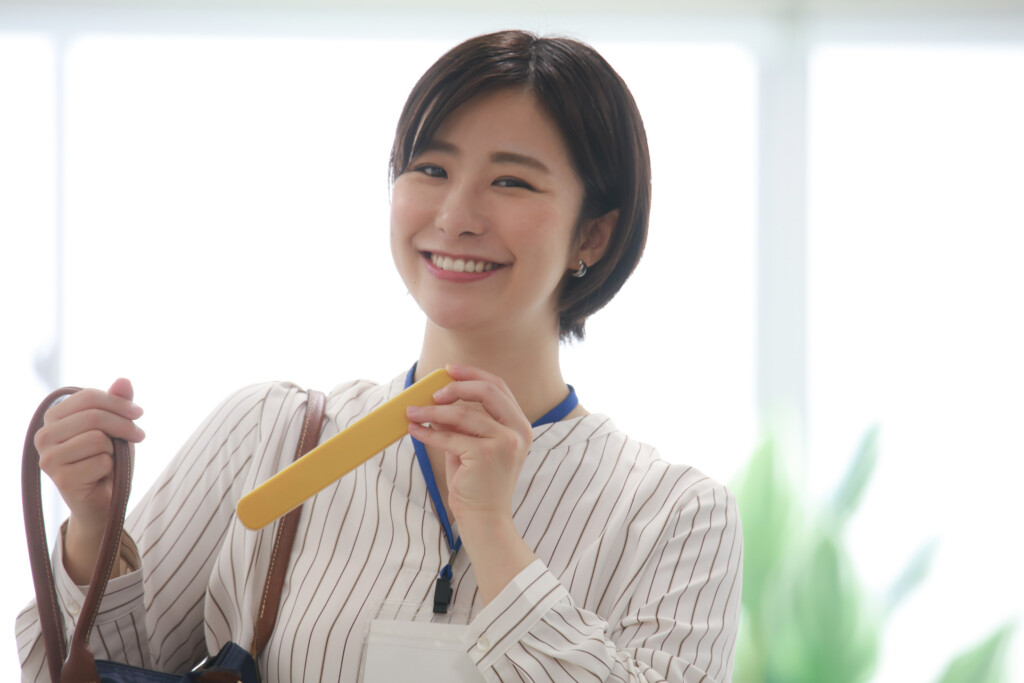 社員証をつけて軽食を楽しむ女性
